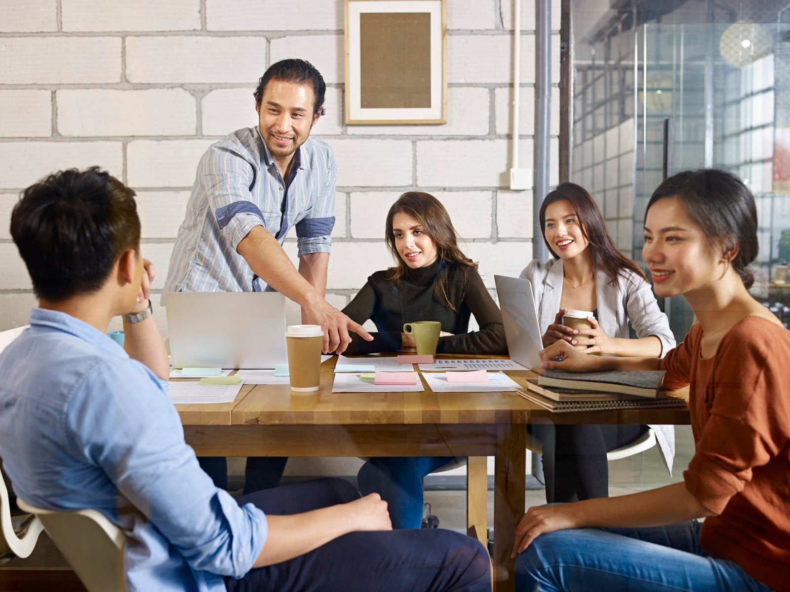 team of asian and caucasian entrepreneurs meeting in office