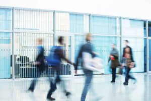 Busy corporate hallway, illustrating the bustling environment of leaders managing their priorities and practicing effective time management for leadership success.